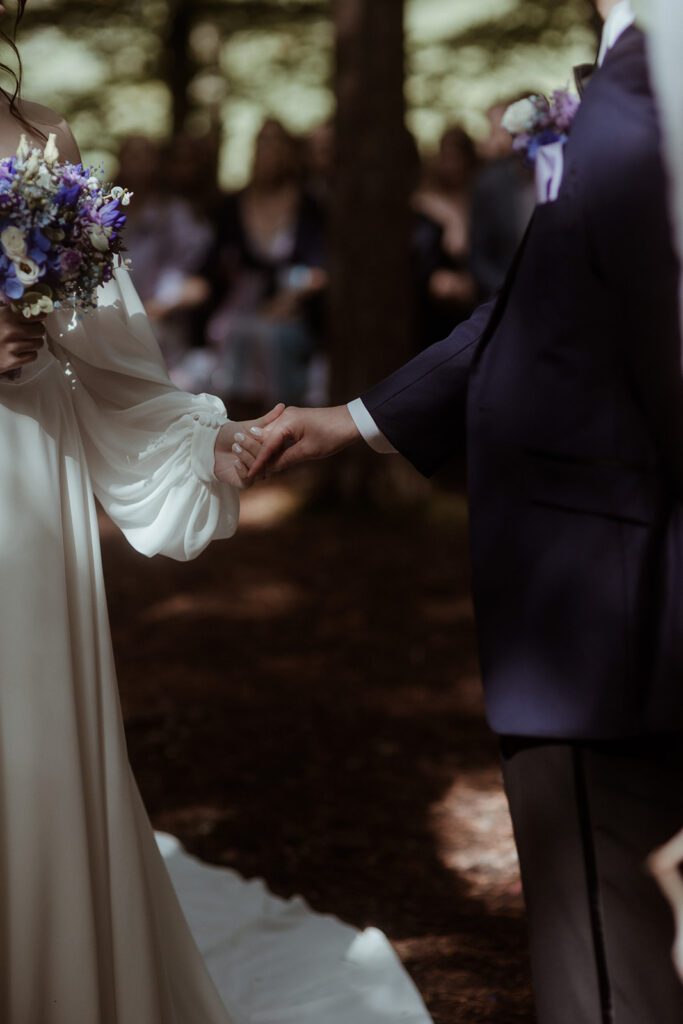 Detailaufnahmen der haltenden Hände bei einer Hochzeit in der Waldhochzeit Edelstauden