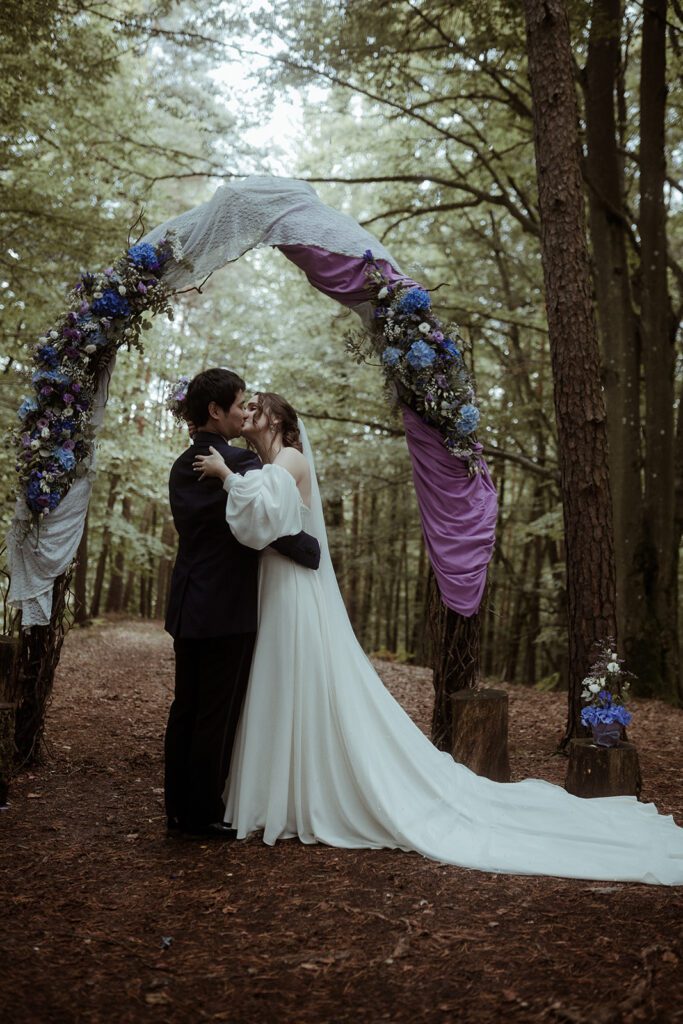 Brautpaar verlässt strahlend die Trauung bei der Waldhochzeit Edelstauden im moody Stil