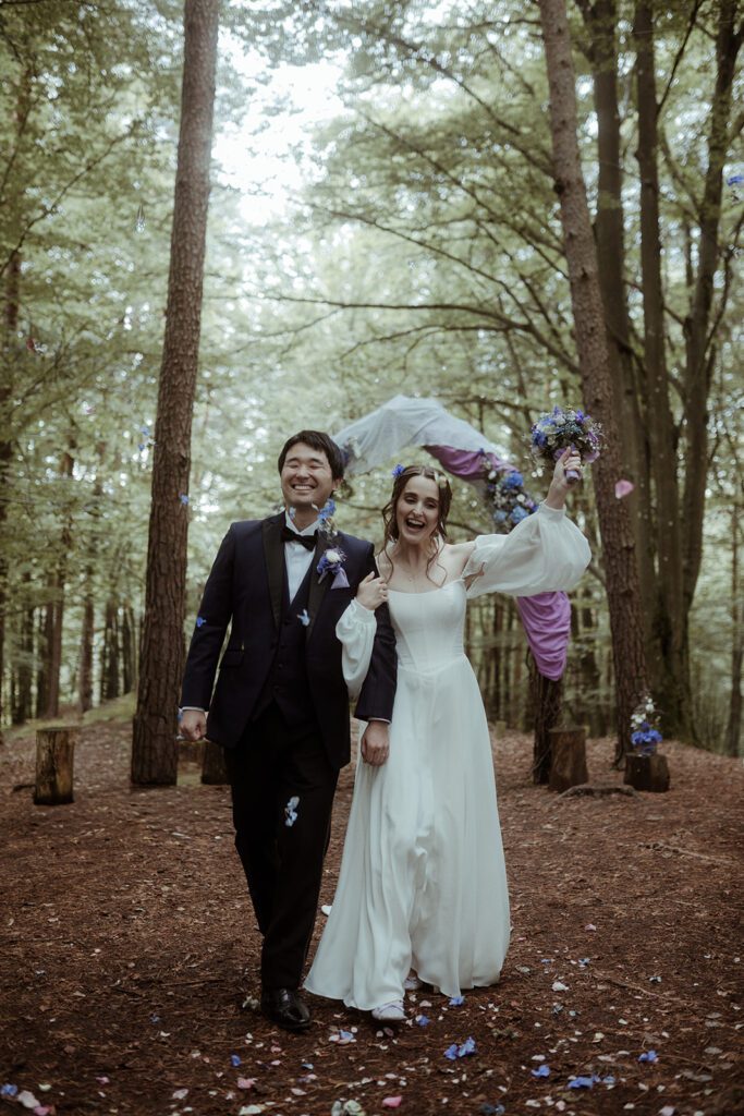 Braut und Bräutigam beim Auszug nach der Trauung bei der Waldhochzeit Edelstauden, moody Hochzeitsfotografie Graz