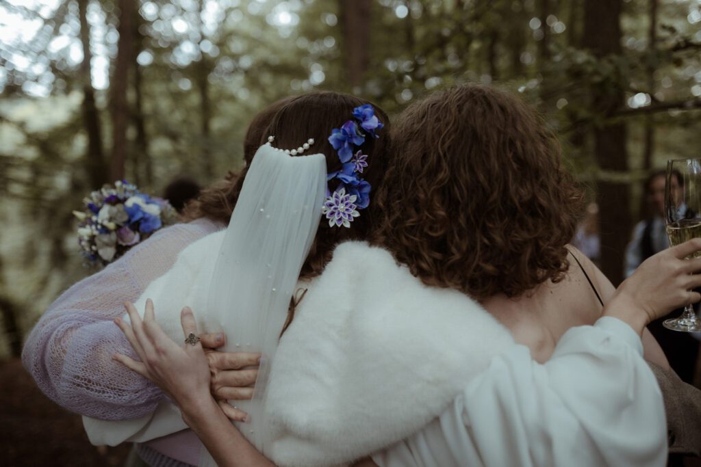 emotionales Hochzeitsfoto der Gäste zwischen den Bäumen der Waldhochzeit Edelstauden