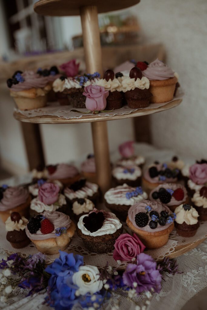 Braut und Bräutigam schneiden gemeinsam die Hochzeitstorte, moody Stimmung, Waldhochzeit Edelstauden