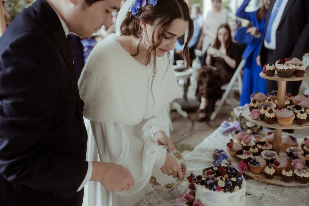 Artsy Moment: Brautpaar beim Tortenanschnitt auf der Waldhochzeit Edelstauden