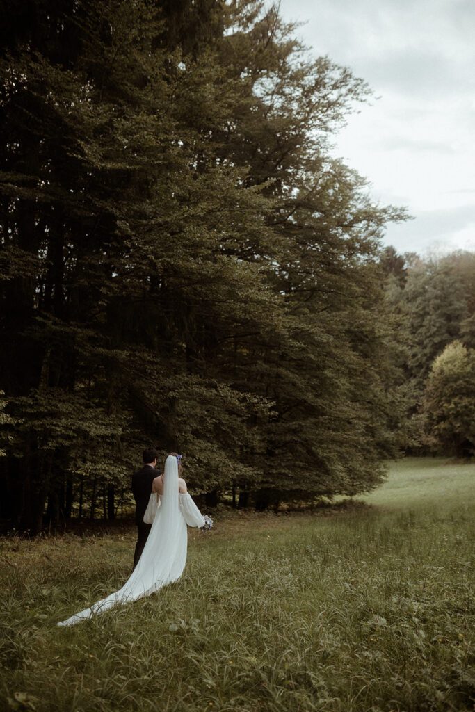Braut und Bräutigam bei romantischem Paarshooting auf der Wiese der Hochzeitslocation Waldhochzeit Edelstauden