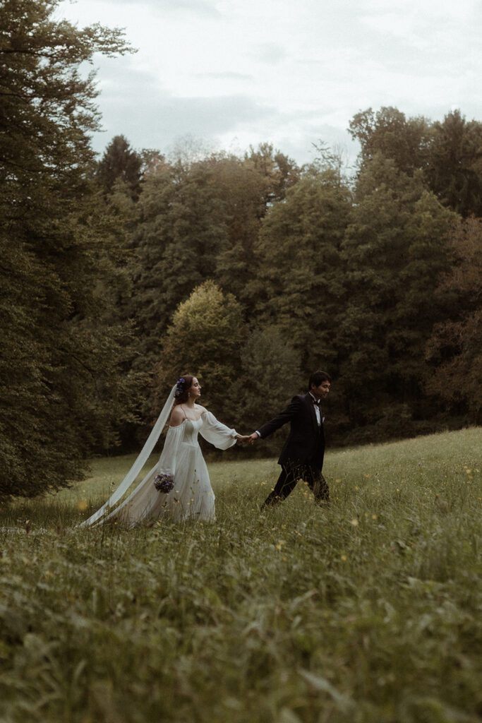Romantische Hochzeitsfotos auf der Wiese, Braut in weißem Kleid und Bräutigam im Anzug bei der Waldhochzeit Edelstauden