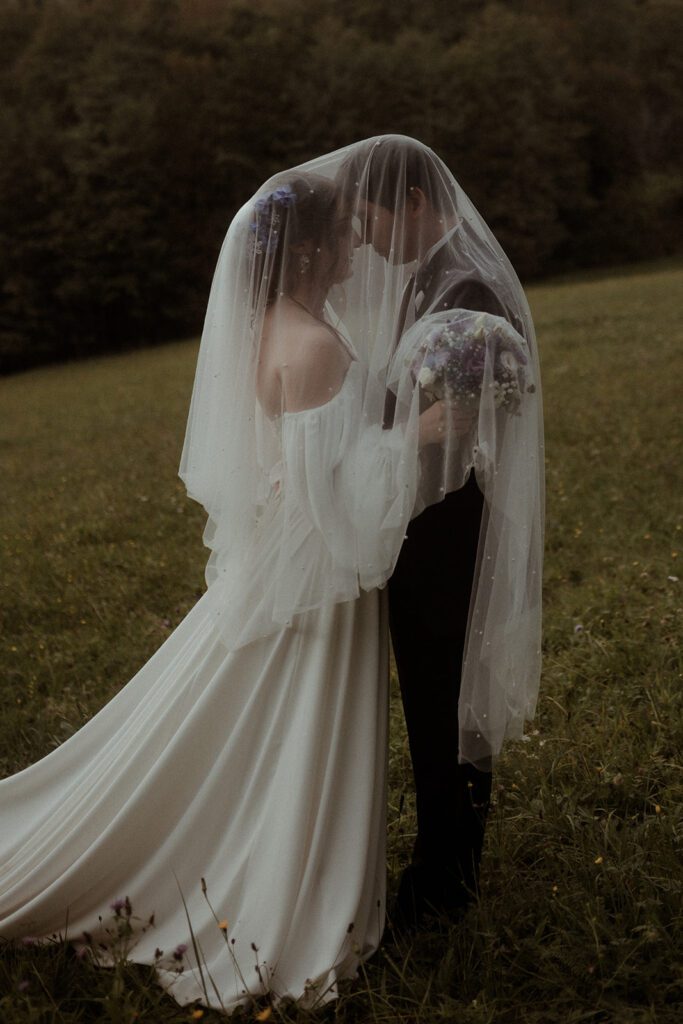Artsy Hochzeitsfoto des Brautpaares zwischen Bäumen bei der Waldhochzeit Edelstauden, Graz