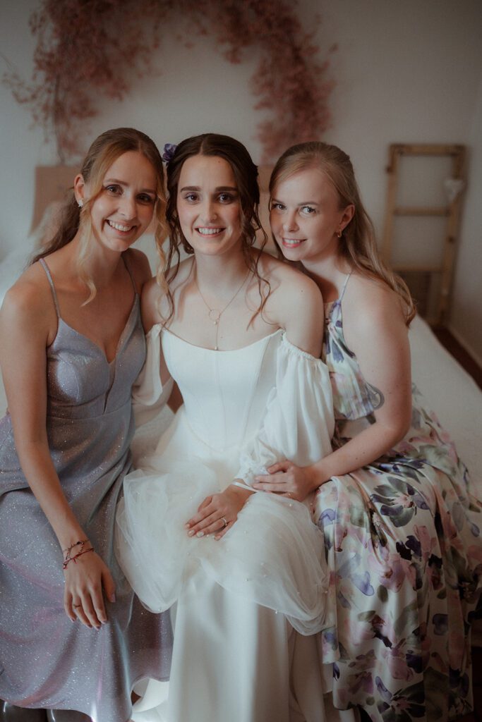 Braut lässt sich stylen beim Getting Ready, moody Stil, Hochzeitsfotografin Graz