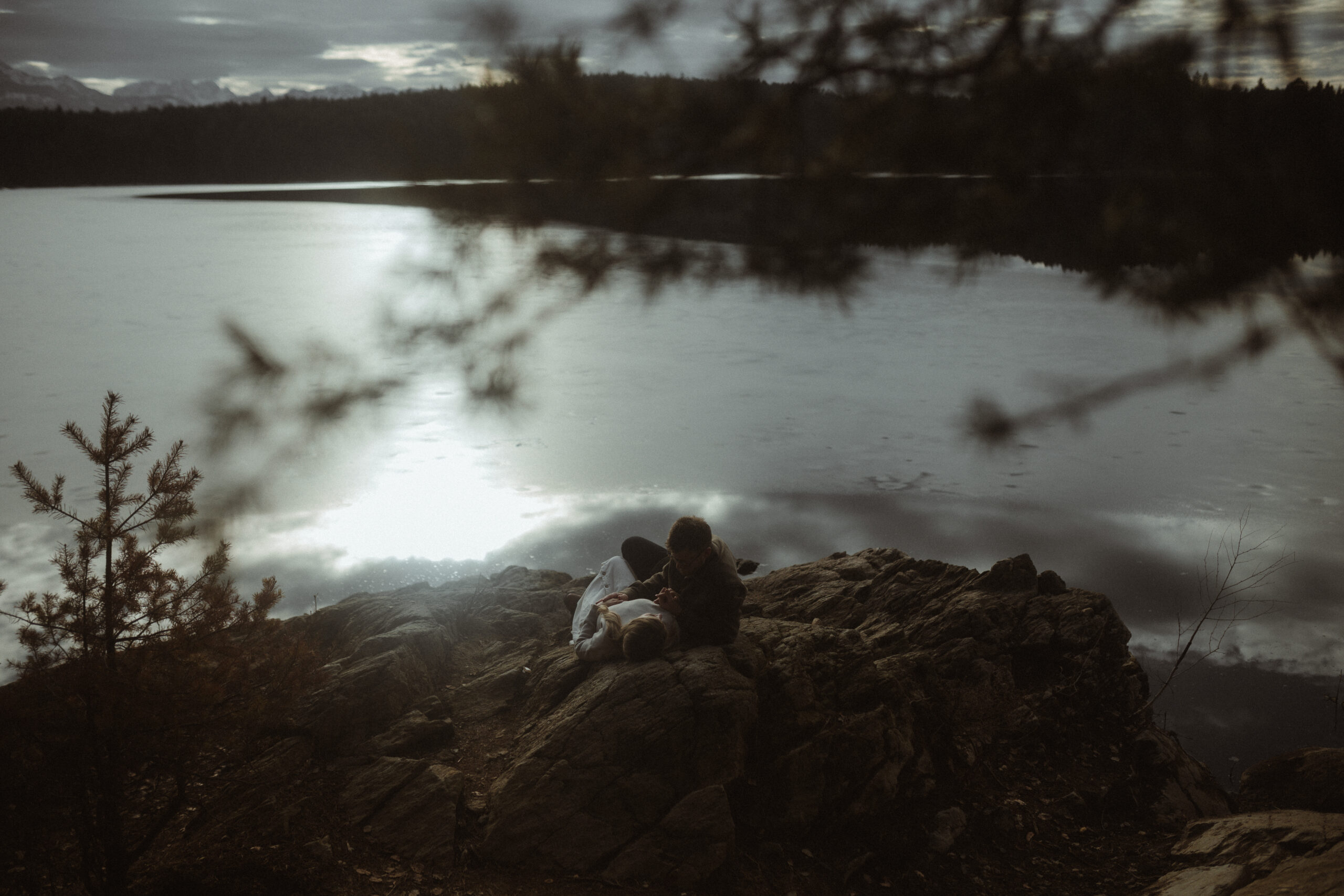 Mathias küsst Sophie auf die Stirn am Ufer des Forstsees, Paarfotografie