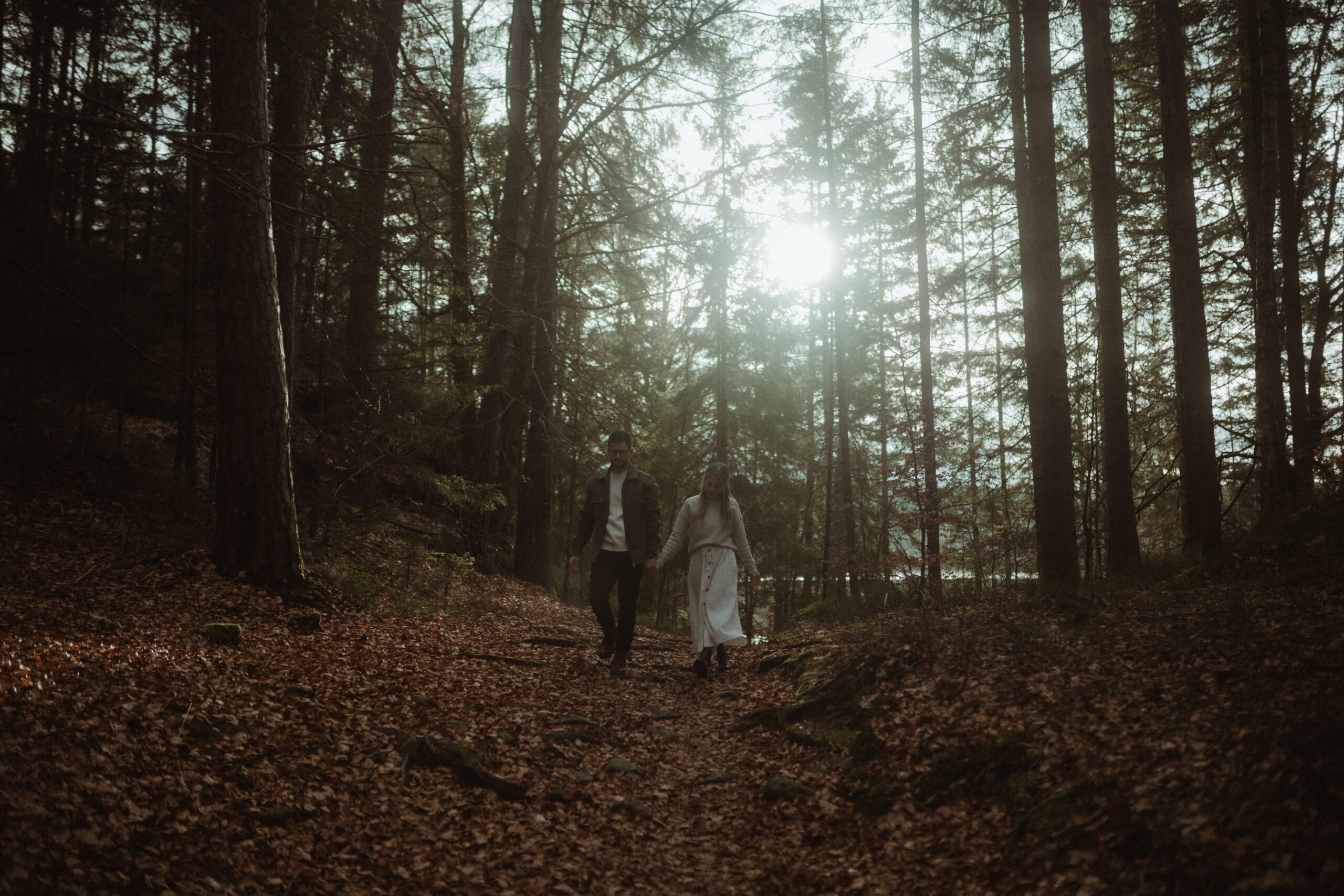 Abschlussaufnahme: Mathias und Sophie Hand in Hand, See im Hintergrund. Paarshooting am Forstsee Kärnten