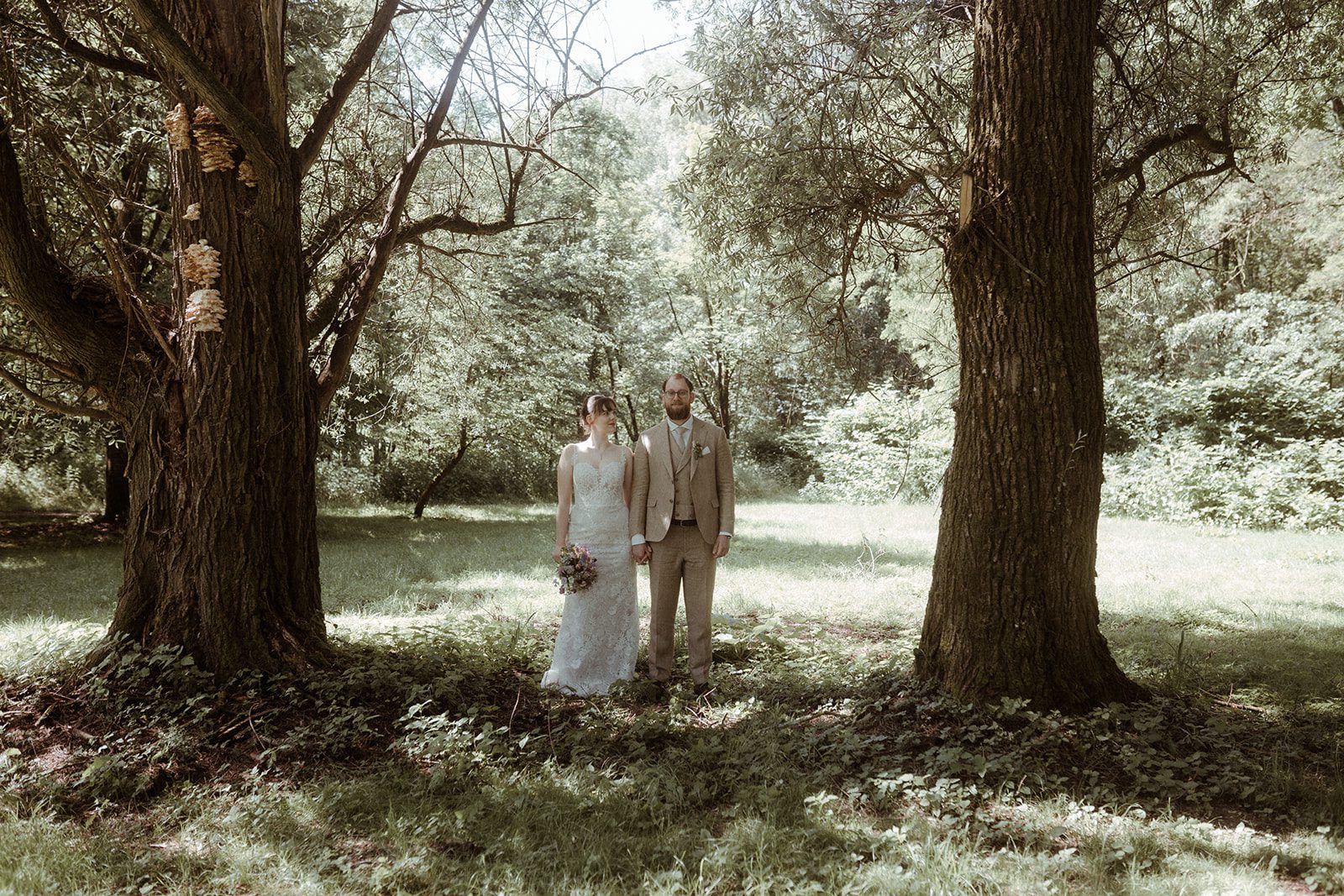 Das Hochzeitspaar steht im Wald